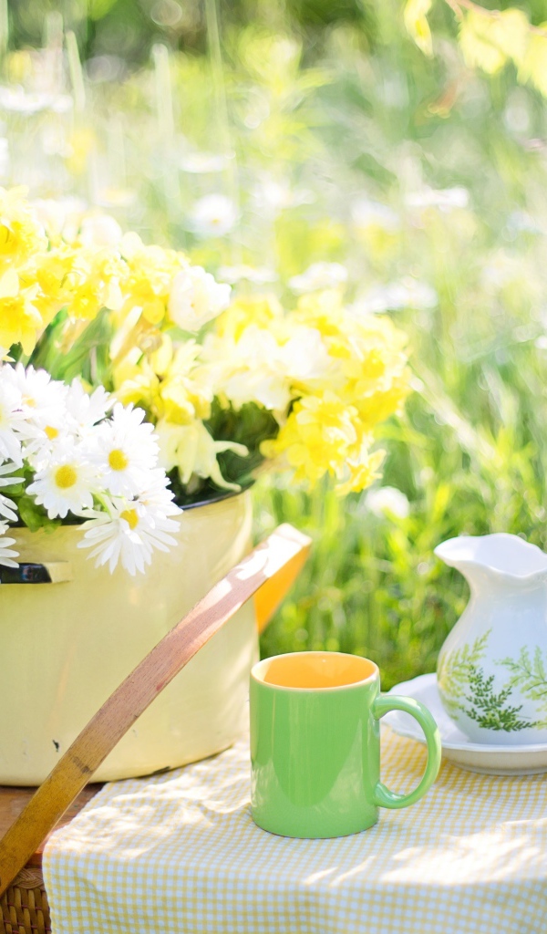 Букет цветов в кастрюле стоит на корзине 