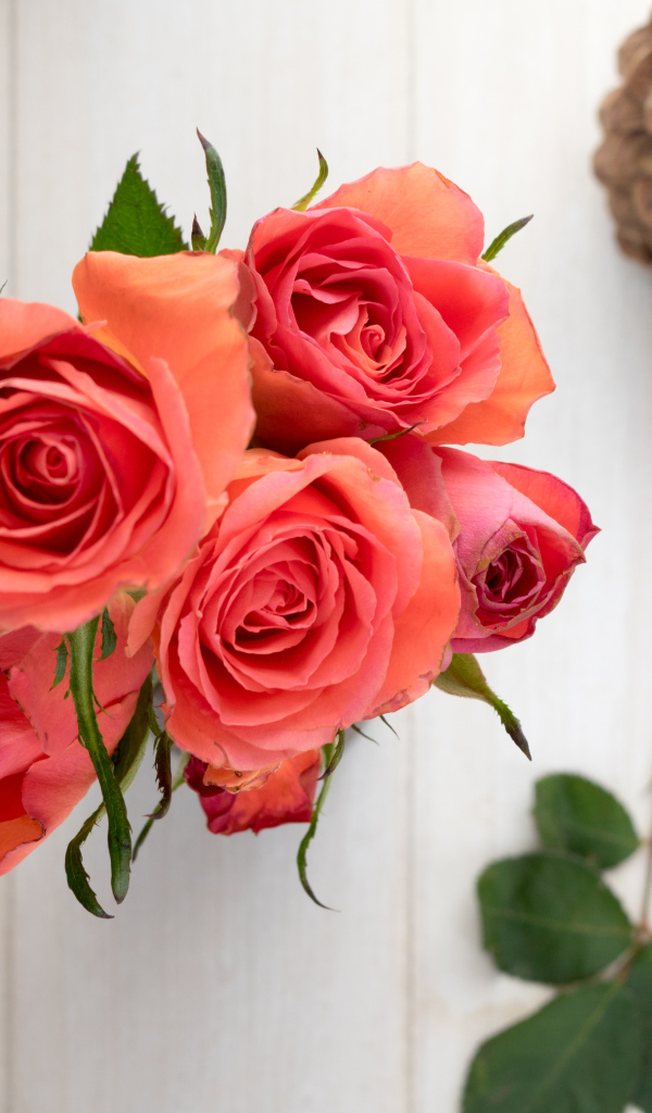 Букет розовых роз на столе с каштанами и шишкой