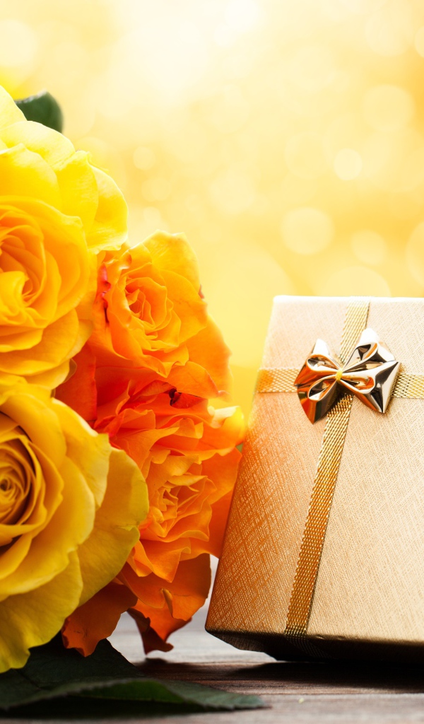 Подарок с букетом желтых роз на столе 