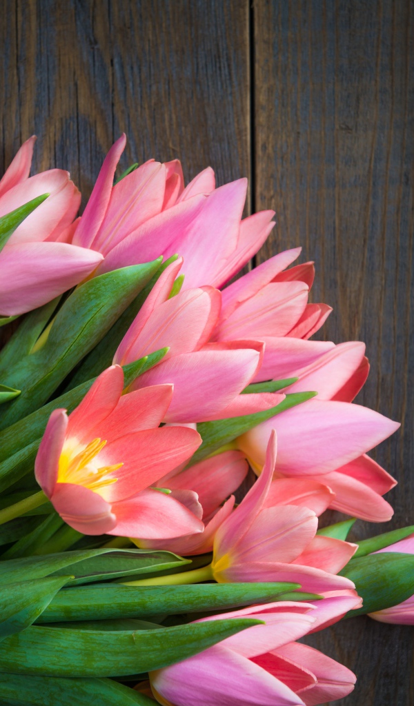 Красивый букет розовых тюльпанов на деревянном столе