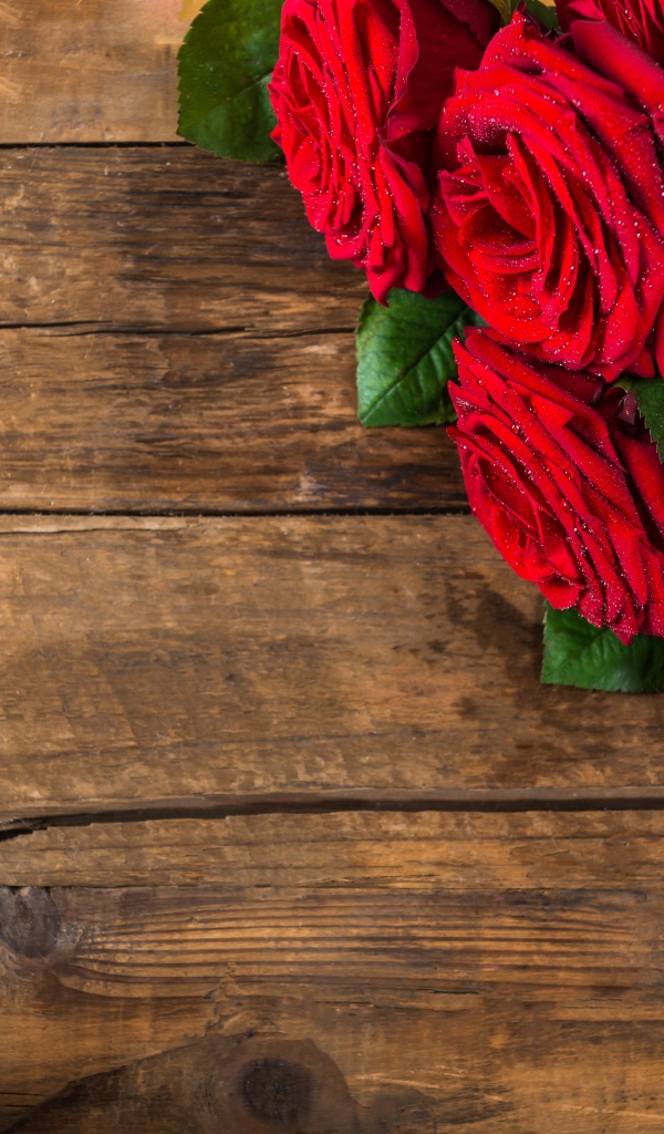 Beautiful bouquet of red roses on a wooden background