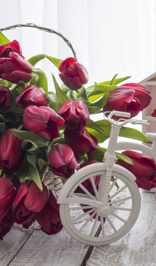 Красивый букет красных тюльпанов на столе с клубникой 