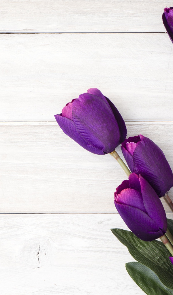 Букет искусственных фиолетовых тюльпанов на деревянном фоне