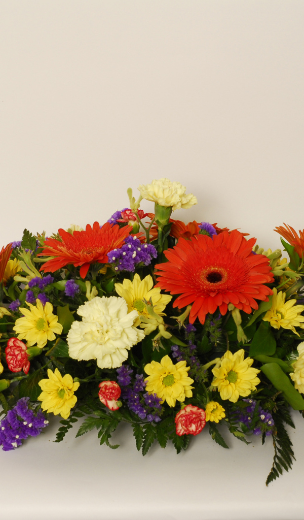 Букет разных разноцветных цветов на сером фоне