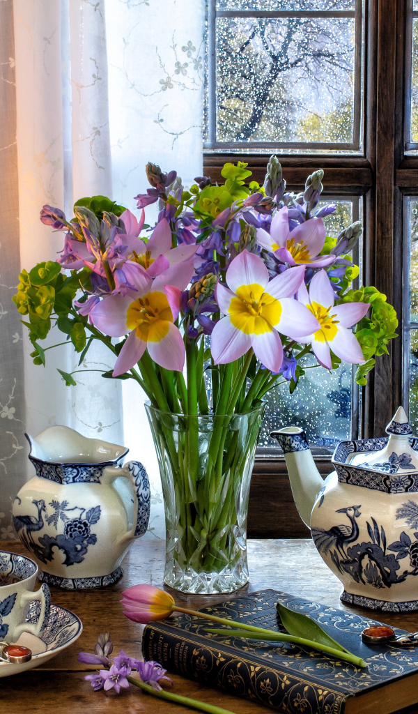 Букет цветов в вазе на столе с красивым сервизом