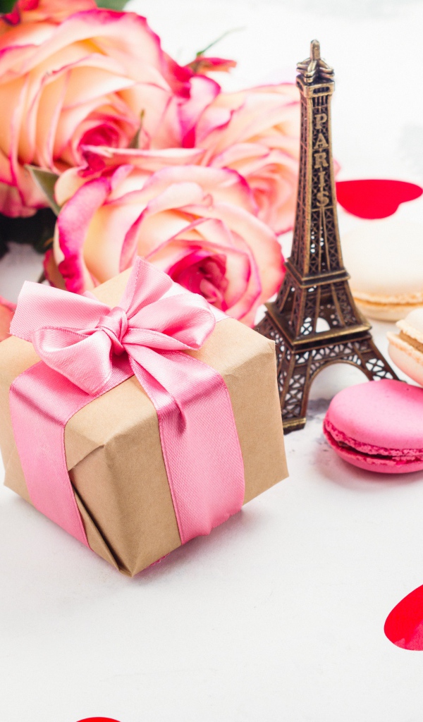 Букет роз на столе с фигуркой Эйфелевой башни и подарком