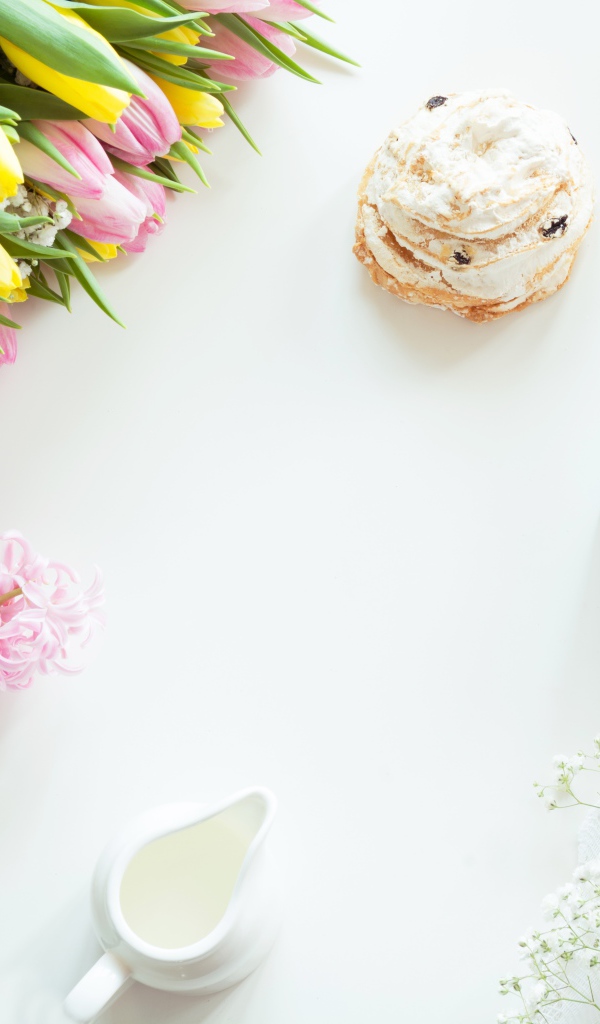 Букет тюльпанов и гиацинт на столе с пирожным и чашкой какао 