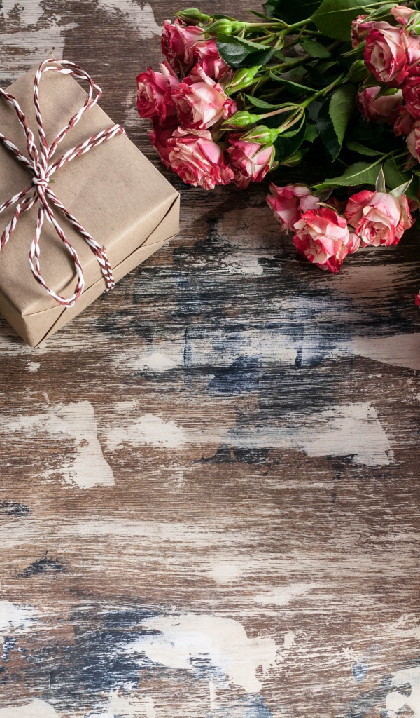 Подарочные коробки на деревянной поверхности с букетом роз