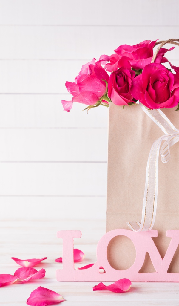 Пакет с розами на столе с надписью Love