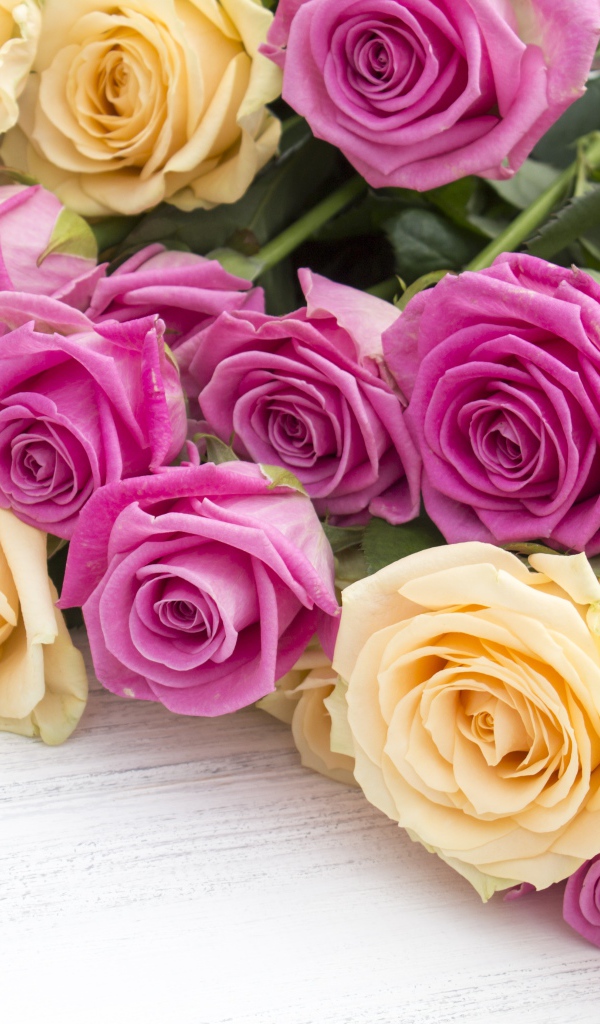 Розовые и белые розы на белом столе 