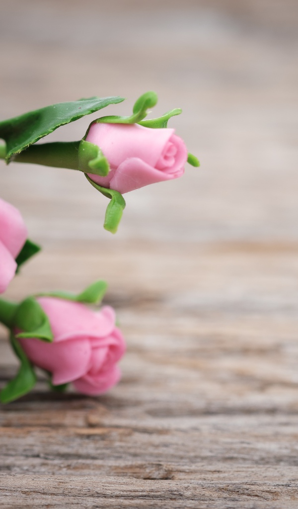 Розовые искусственные розы с сердцем на деревянном фоне