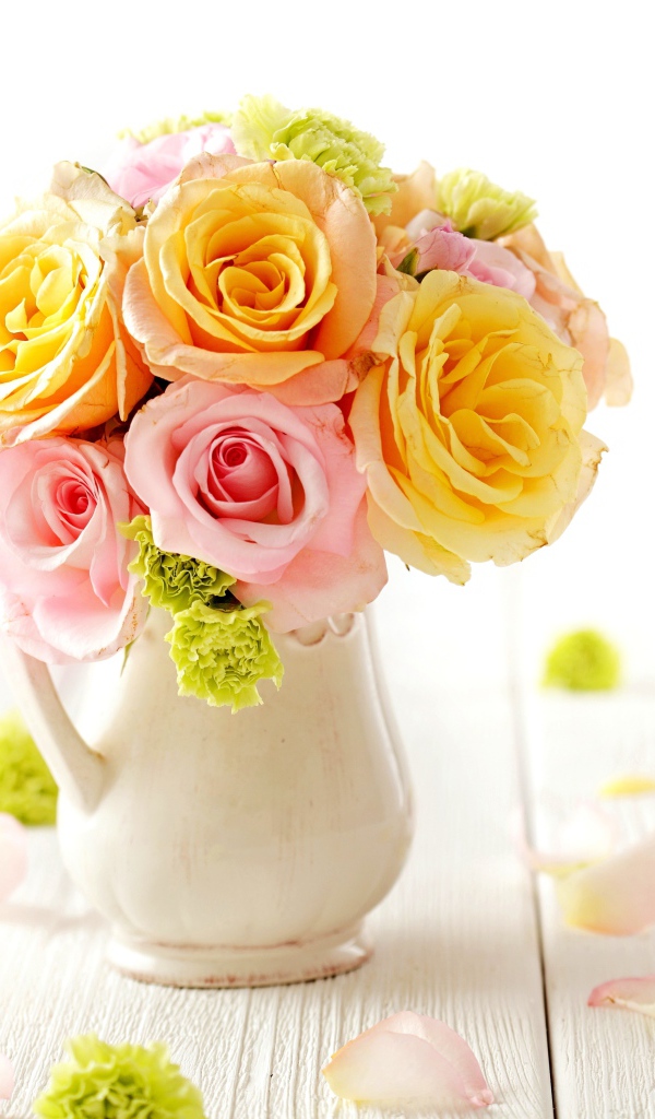 Желтые и розовые розы в вазе на столе 