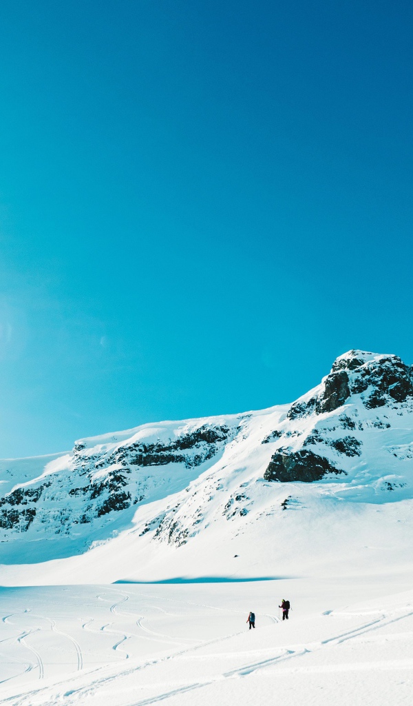 Красивые заснеженные горы под голубым небом в лучах солнца 