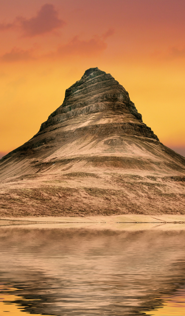 Гора отражается в воде на фоне неба на закате