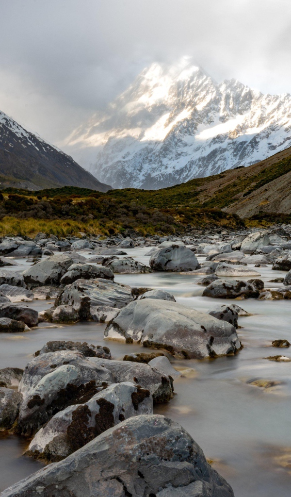 Stones in the water at the snow-capped mountains