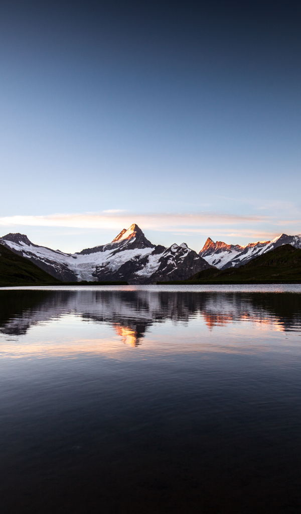 Спокойное горное озеро у заснеженных гор 