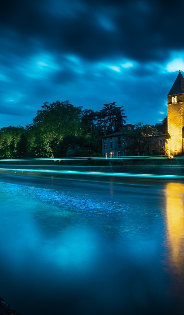 Башня на берегу реки ночью 