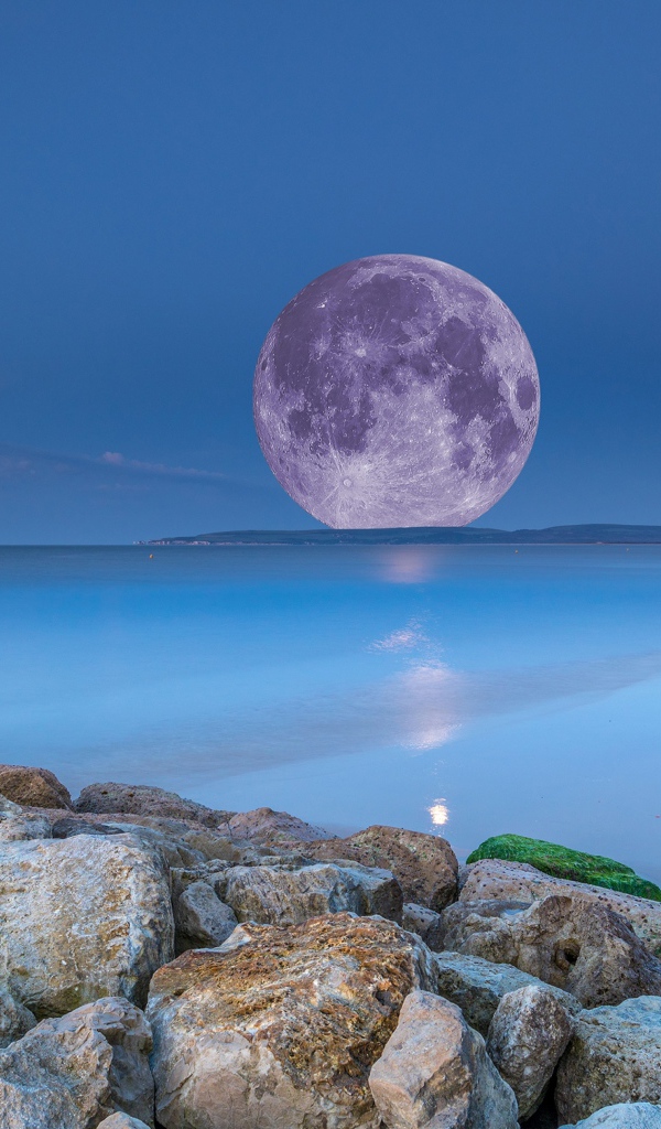 Огромная белая луна на горизонте в море