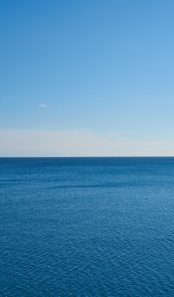 Спокойная морская вода на фоне голубого неба 