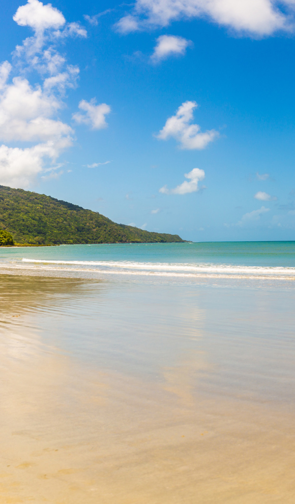 Спокойные волны на песке под красивым голубым небом