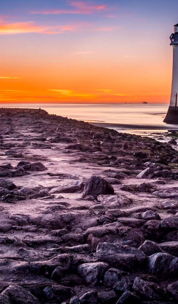 Каменная дорога ведет к маяку у моря