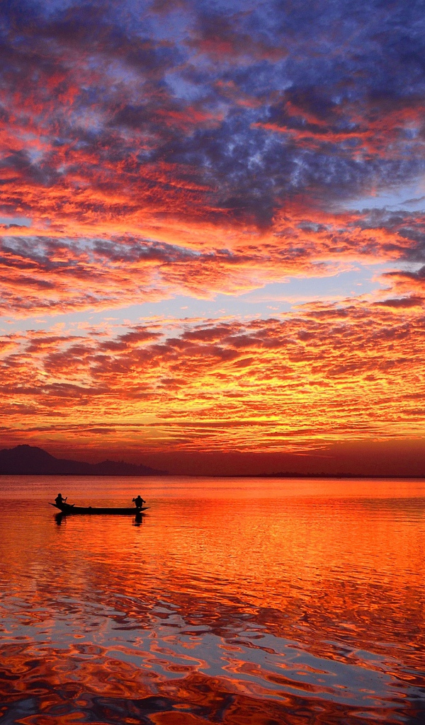 Boat on the water of a calm lake at sunset