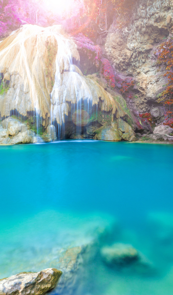 Водопад стекает по скале в голубую воду, Тайланд