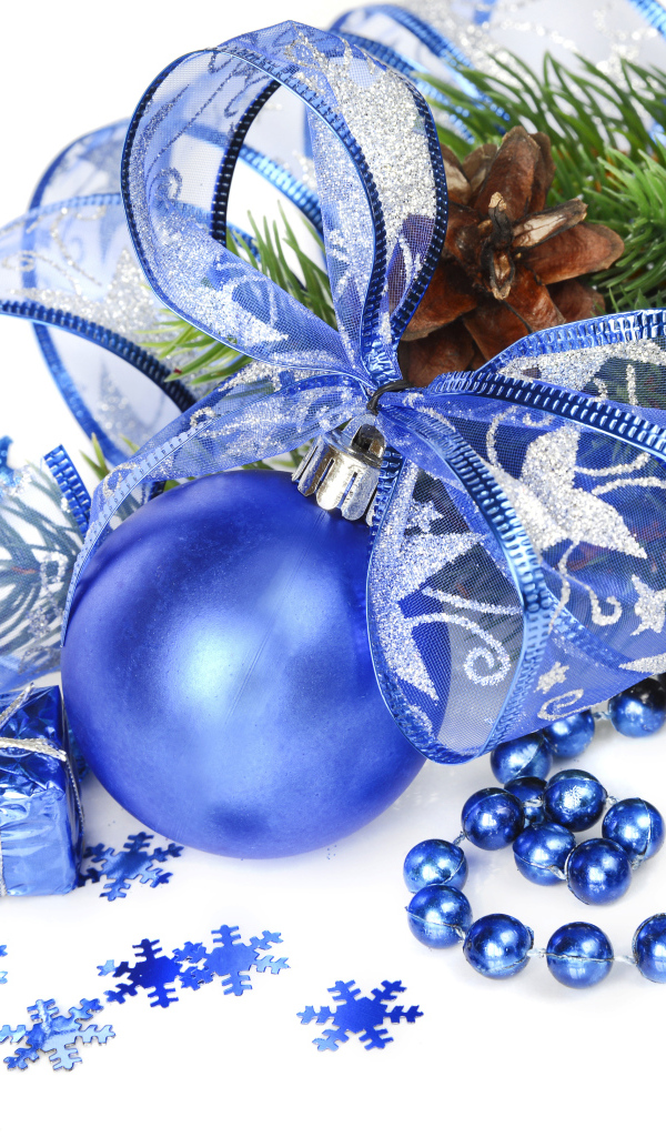 Красивый синий елочный шар с лентой на белом фоне с елочной веткой