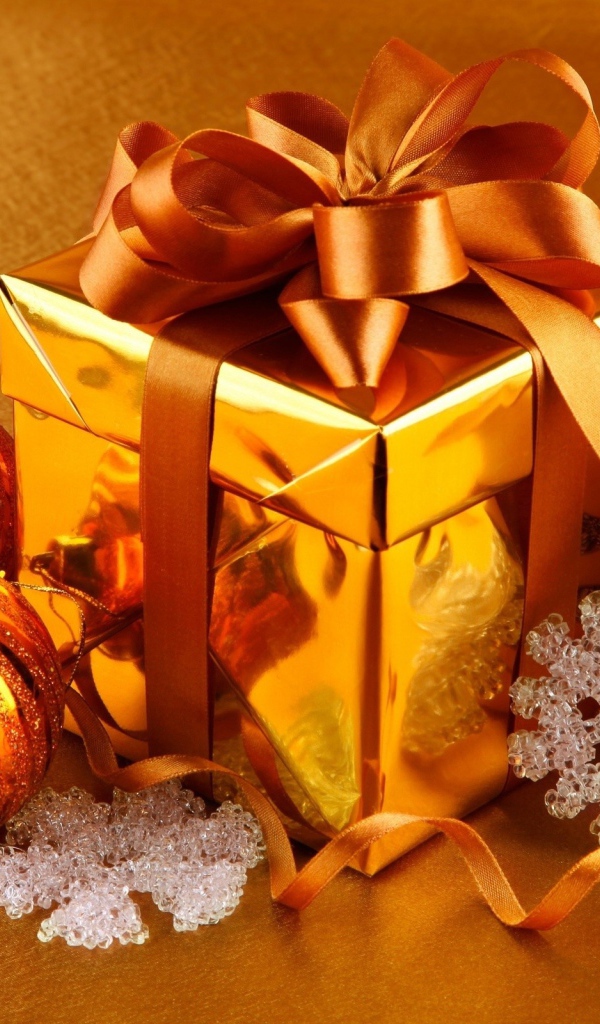 Подарок, елочные шарики и зажженные свечи на новый год 2020 