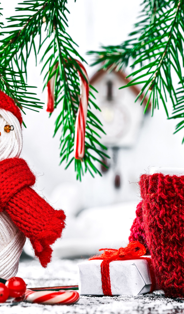 Снеговик из ниток на столе с чашкой и елочными ветками