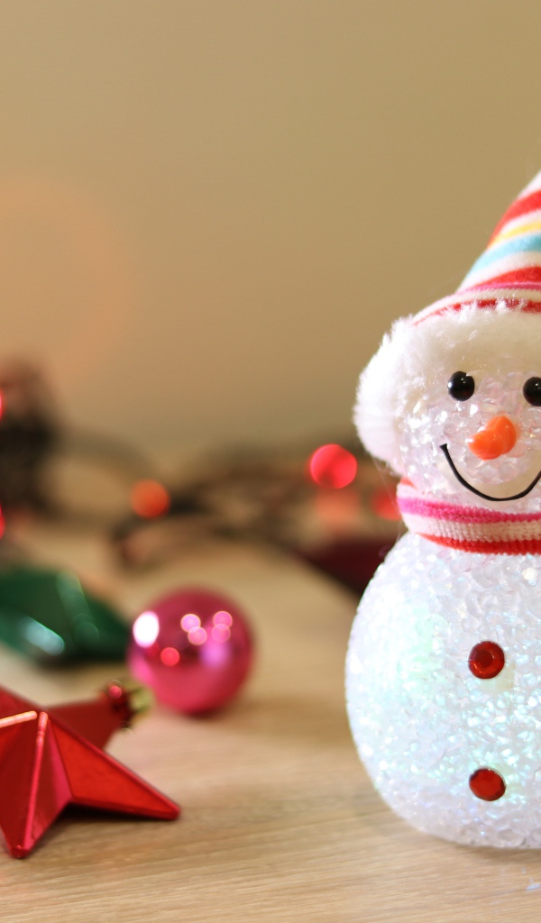 Снеговик с новогодними игрушками на столе