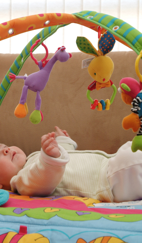 Грудной малыш играет с игрушками