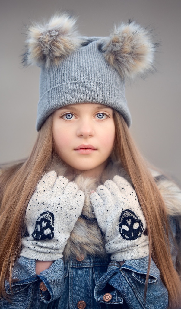 Красивая голубоглазая девочка в теплой шапке
