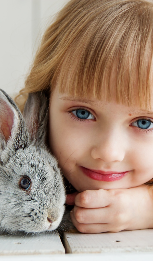 Красивая голубоглазая девочка с серым кроликом