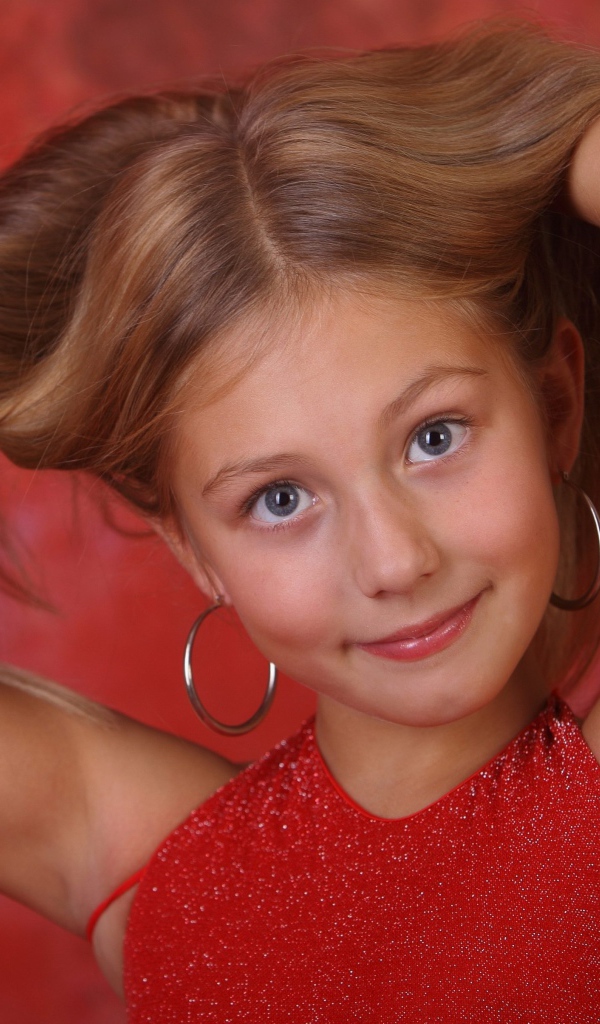 Красивая маленькая девочка с руками в волосах