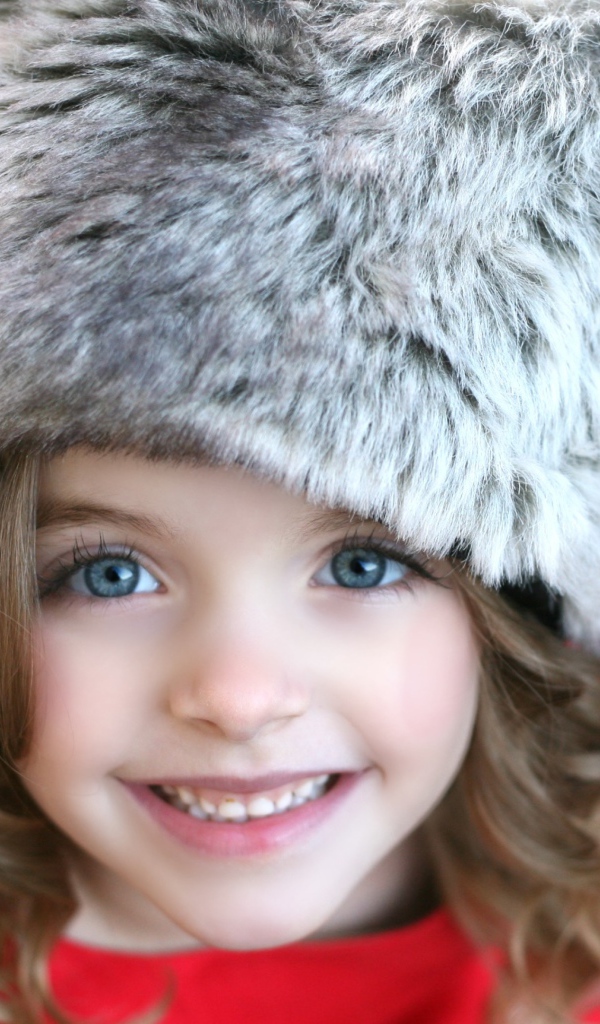 Красивая улыбающаяся девочка в меховой шапке