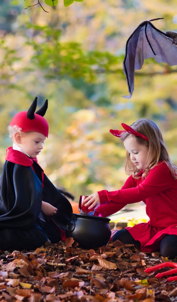 Мальчик и девочка в лесу в костюмах на праздник Хэллоуин 