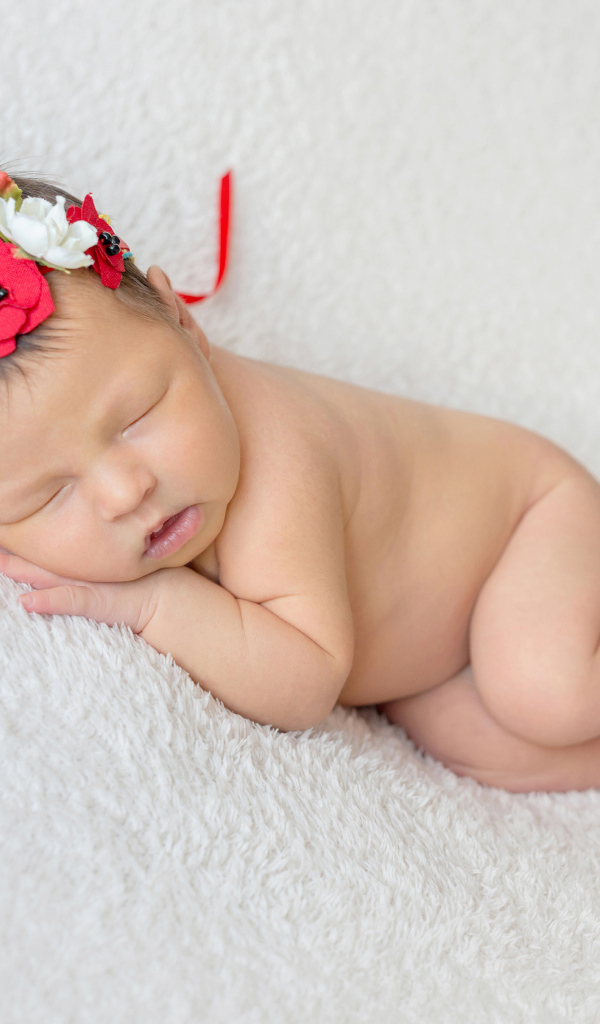 Грудная спящая девочка с венком на голове 