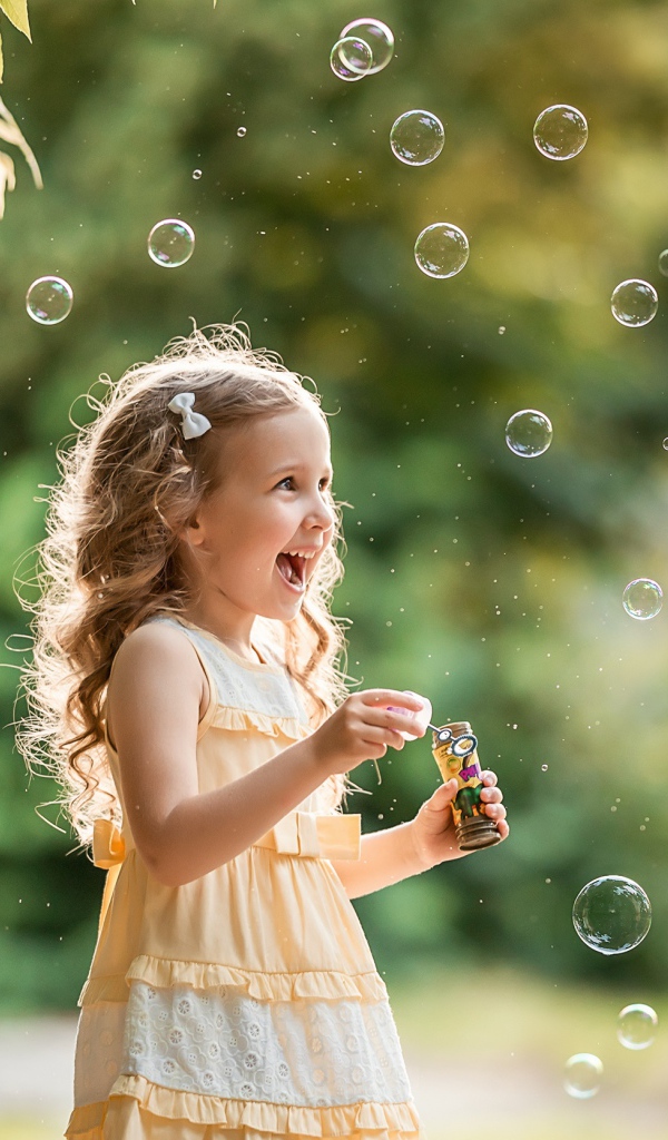 Веселая девочка с мыльными пузырями