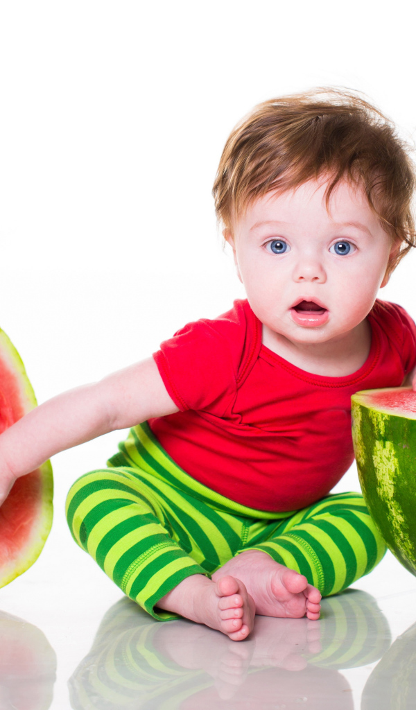 Милый голубоглазый мальчик с арбузом на белом фоне