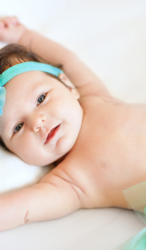 Милая маленькая девочка с повязкой с голубым цветком