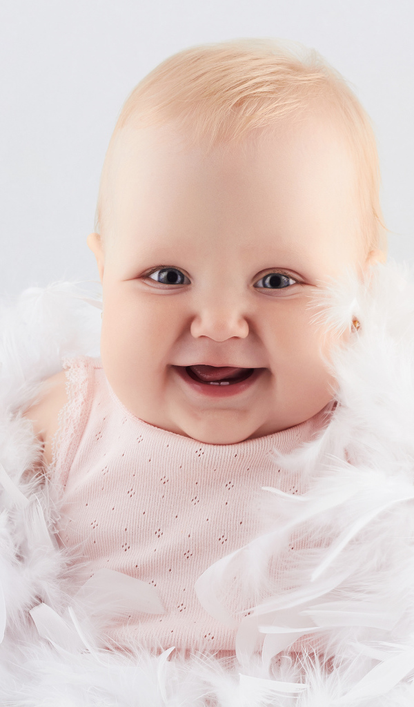 Смеющаяся маленькая девочка с перьями