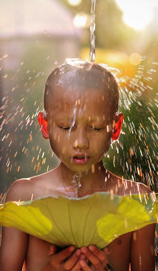Маленький мальчик азиат умывается водой