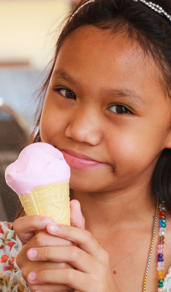 Маленькая девочка азиатка с мороженым в руке