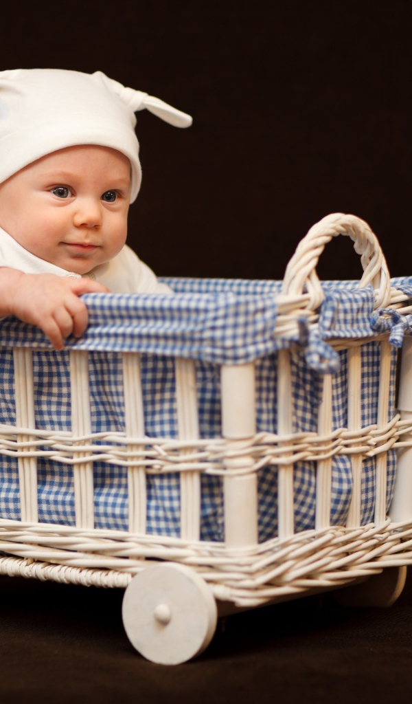 Маленький ребенок в кроватке на колесах 