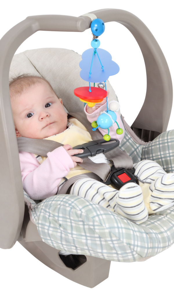 Маленький грудной ребенок в автомобильном кресле на белом фоне