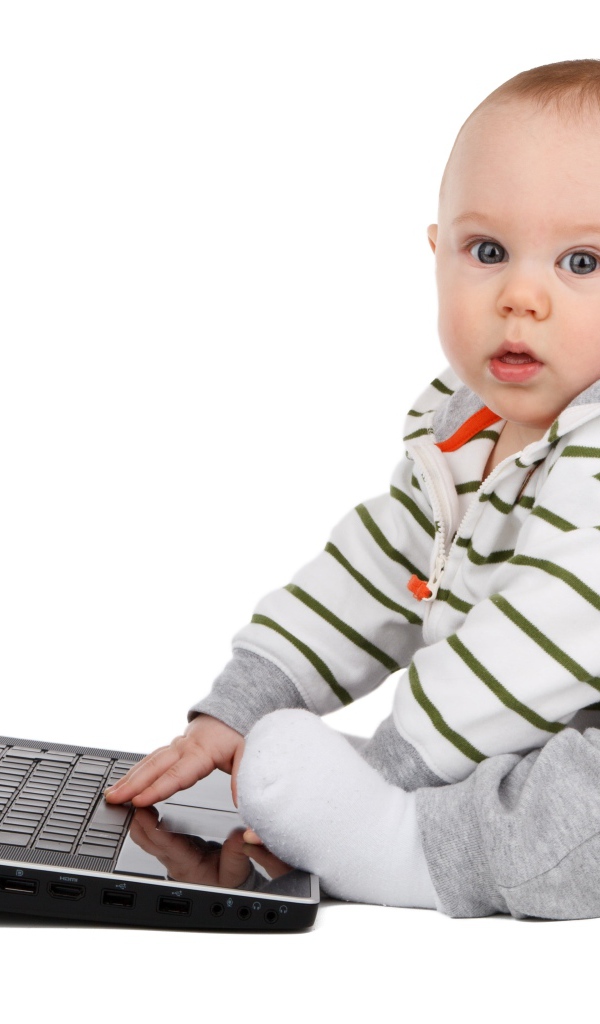 Маленький ребенок сидит с ноутбуком на белом фоне