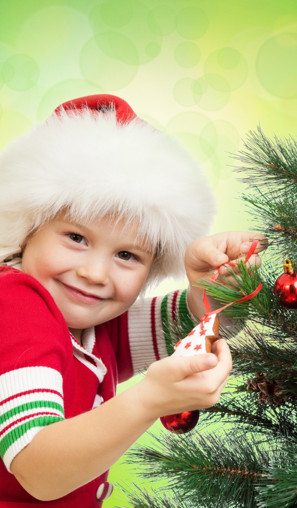 Маленькая красивая девочка наряжает елку на новый год