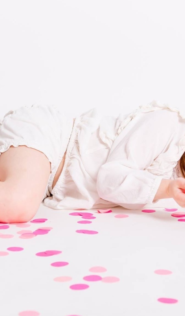 Маленькая голубоглазая девочка лежит на полу