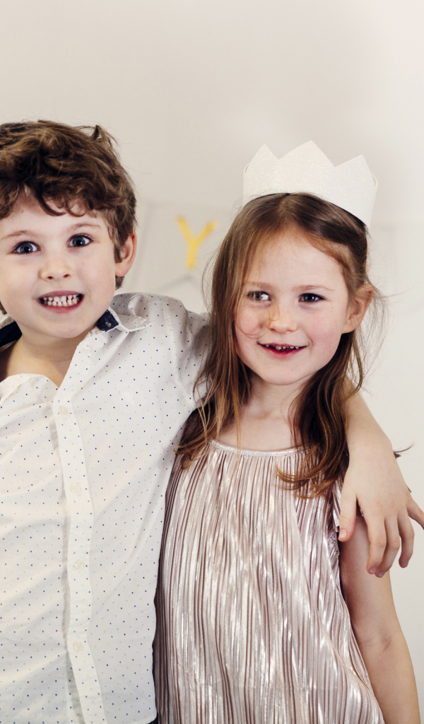 Маленькие мальчик и девочка на празднике с воздушными шарами